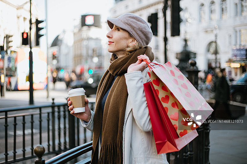 手提购物袋站在摄政街的年轻女子图片素材