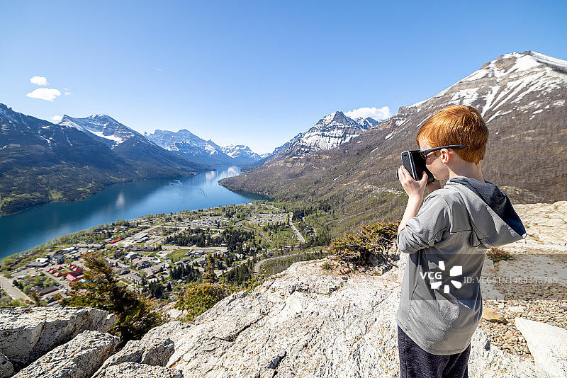 在加拿大沃特顿湖国家公园熊峰小径顶端拍摄照片的红发男孩图片素材