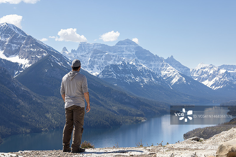 年轻男人在加拿大沃特顿湖国家公园熊峰步道徒步旅行时欣赏风景图片素材