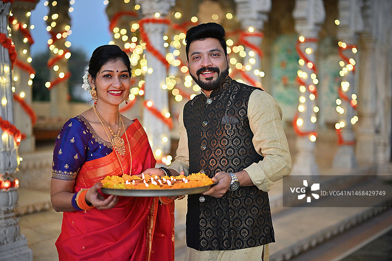 宫殿中身着传统服装的中年夫妇手持油灯肖像图片素材