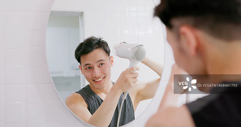 使用吹风机的亚洲男人图片素材