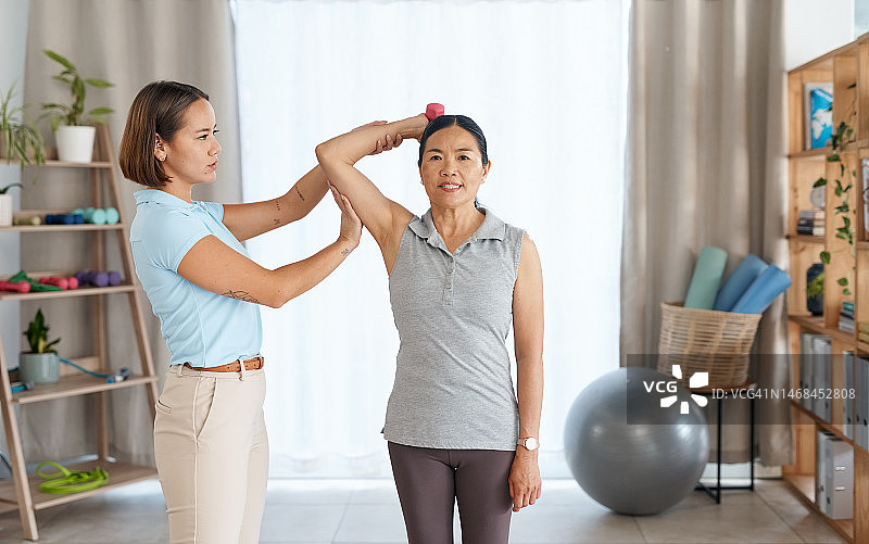 理疗肖像：哑铃或老年妇女在手臂恢复康复或运动训练中获得帮助。物理治疗诊所或理疗师帮助亚洲病人健身图片素材