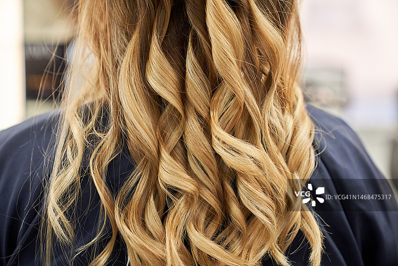 在美发沙龙中为女顾客烫发的女理发师图片素材