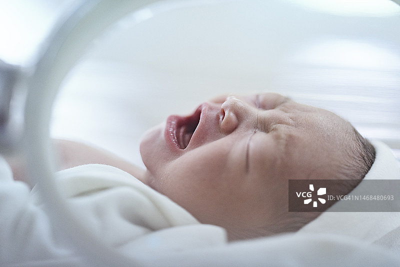 在保育箱中哭泣的亚洲新生儿图片素材