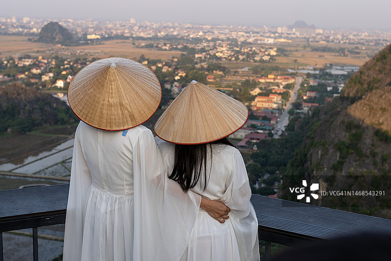 中国母女在越南宁平名胜古迹穿着越南传统服装和帽子图片素材