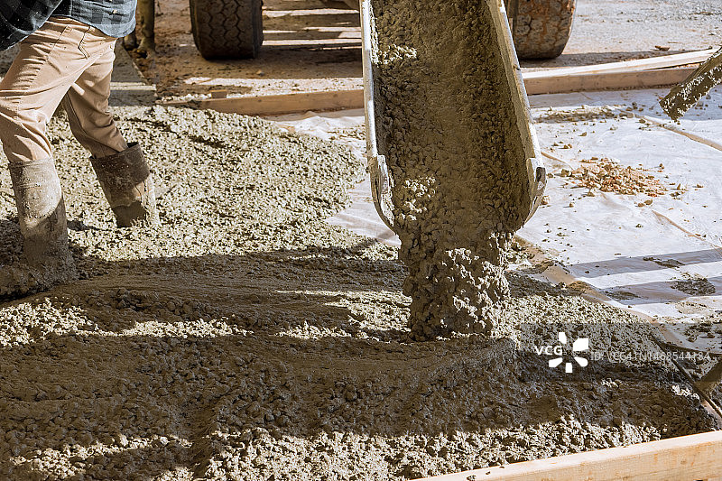 混凝土搅拌车将混凝土倾倒在建筑工地上图片素材
