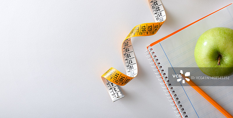 笔记本上的健康计划与苹果和卷尺，西班牙图片素材