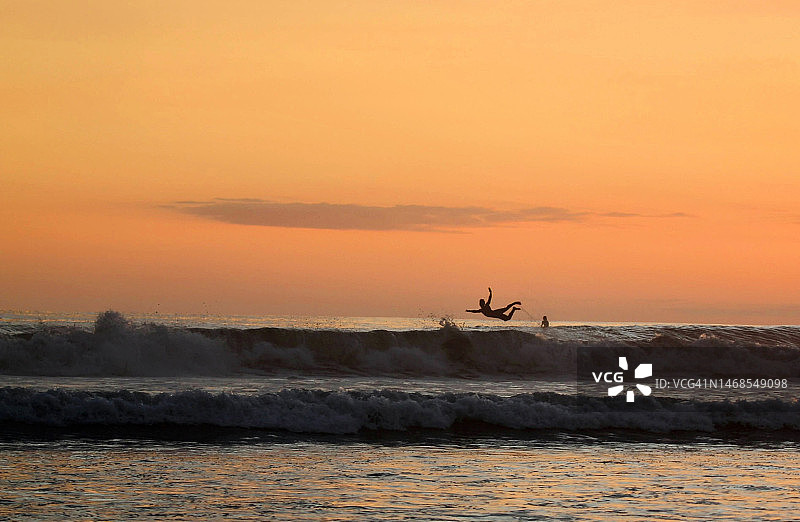 日落时分在海上冲浪的男人剪影，哥斯达黎加图片素材
