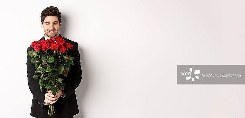 身穿黑色西装手捧红色花束的英俊男友图片图片素材