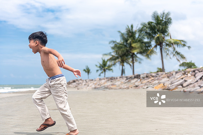 在海滩上奔跑的小男孩图片素材