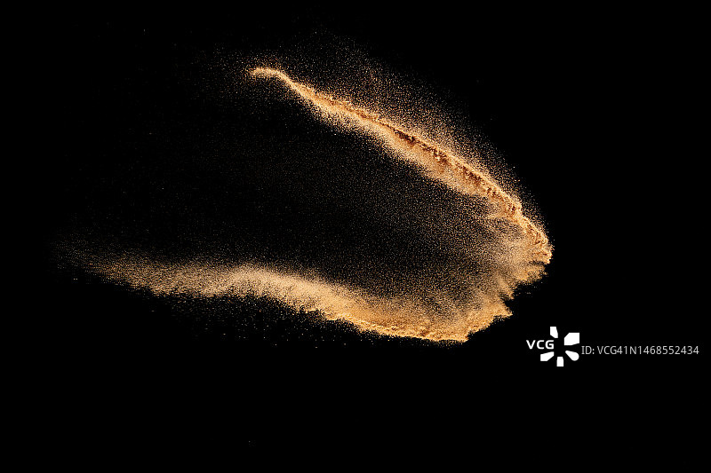 黑色背景下的棕色沙子飞溅，泰国沙蝇波浪图片素材