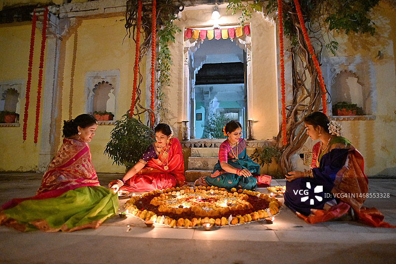 印度妇女在宫殿寺庙入口处用油灯装饰蓝果丽的俯视视角图片素材