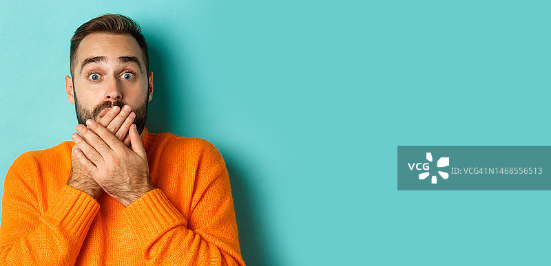 震惊的白人男人捂住嘴唇的特写，凝视图片素材