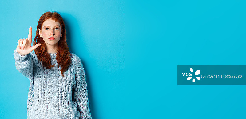 红发女孩做禁忌手势图片素材