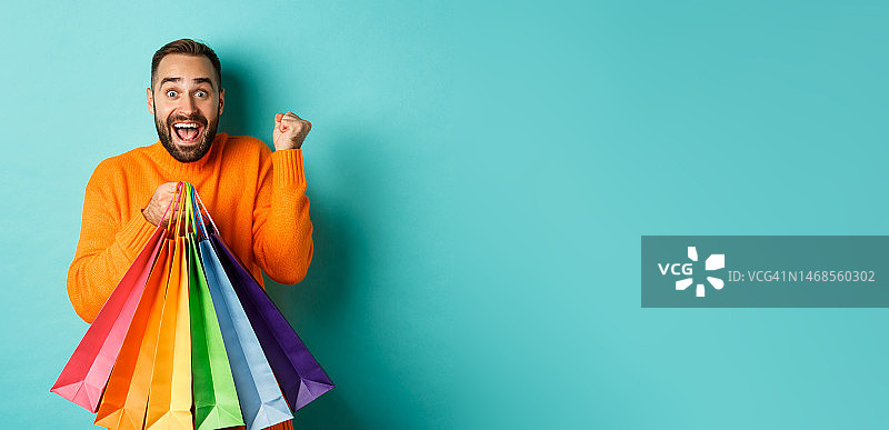 兴奋的男人展示购物袋图片素材