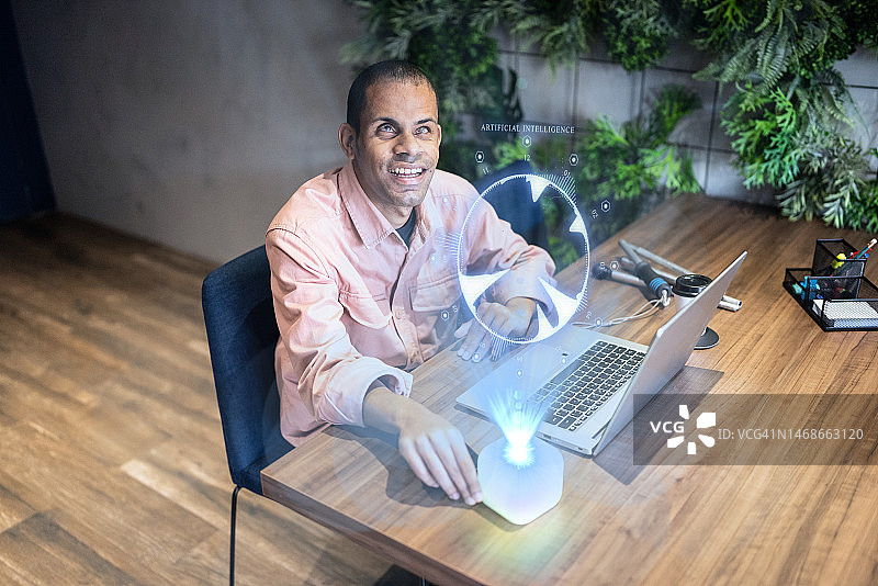 视力障碍男子在办公室使用笔记本电脑和数字智能图片素材