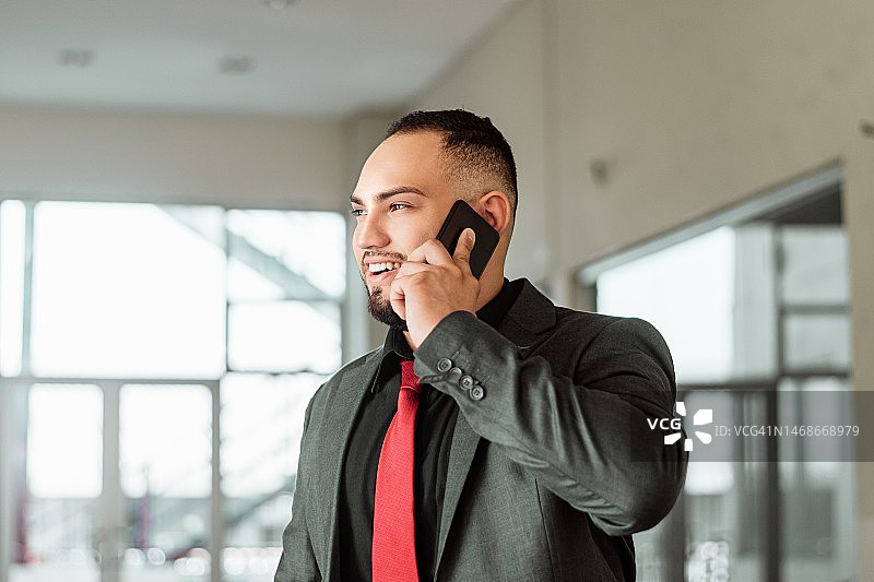 年轻的西班牙裔商人使用智能手机图片素材