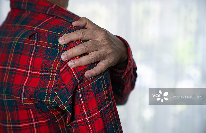 男子手部扶着肩膀，肩部疼痛图片素材