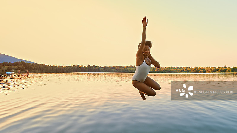 女人在湖里跳跃图片素材