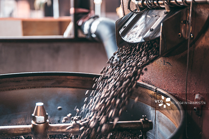 咖啡豆落入冷却盘，通过咖啡烘焙机烘烤图片素材