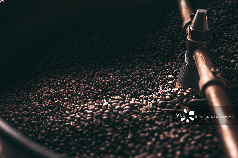 冷却盘中旋转的咖啡豆，咖啡烘焙机烘烤的咖啡豆图片素材