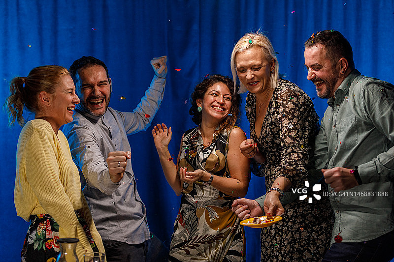 快乐的朋友们在派对彩屑爆炸时玩得很开心图片素材