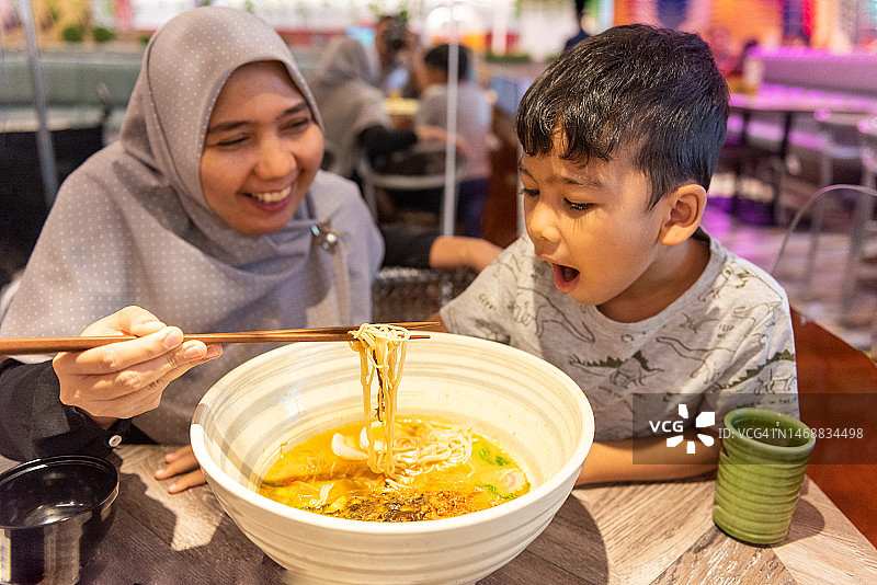 母亲和儿子在大碗里吃拉面图片素材