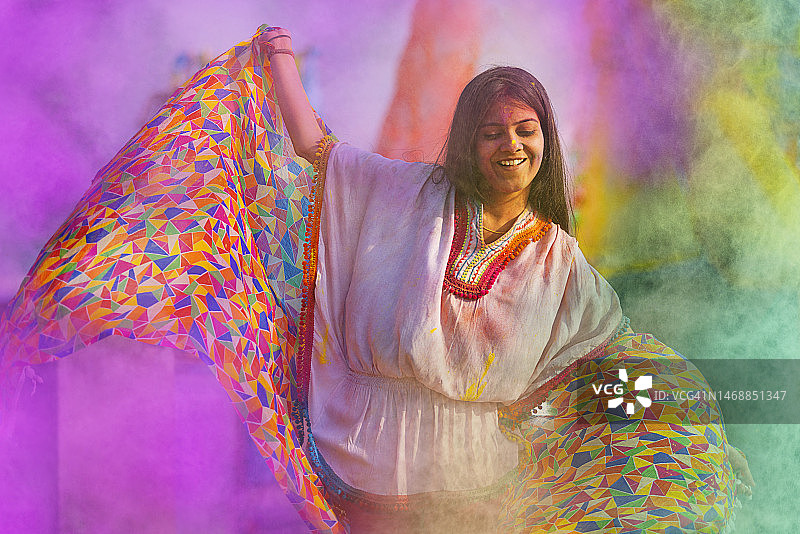 女人在玩洒红节，脸上带着古拉勒跳舞图片素材