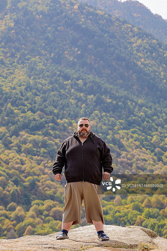 站在山顶的胖男人图片素材