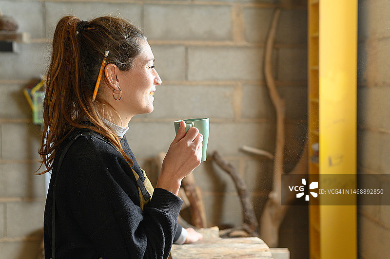 在木制工作坊里喝咖啡的女人图片素材