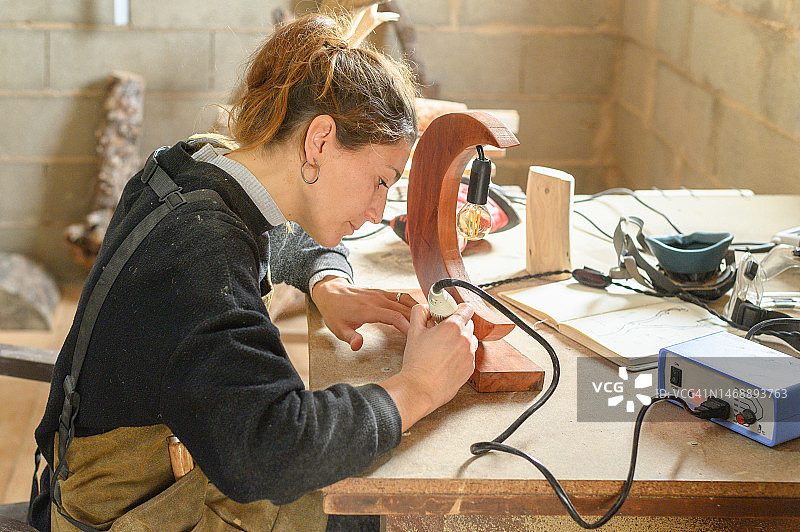 女工匠在木工车间装饰木制灯具图片素材