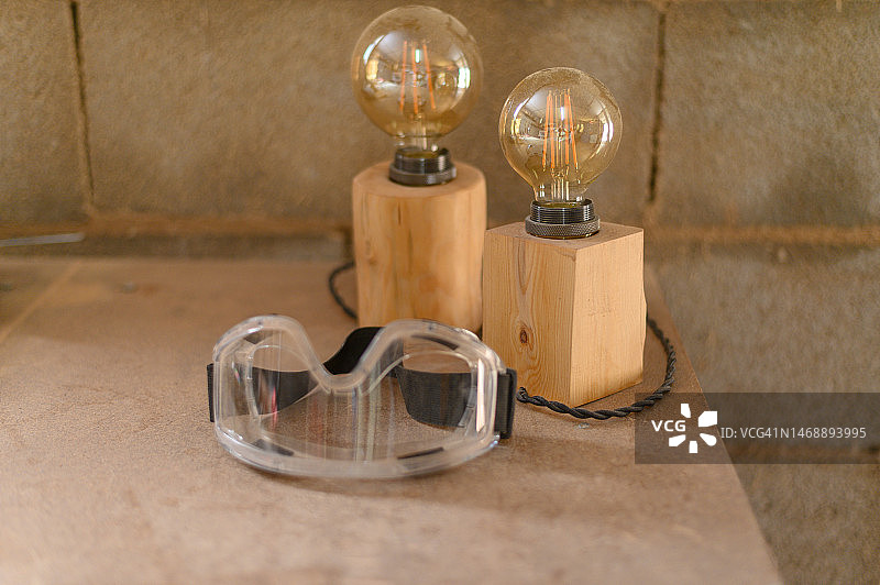 防护眼镜旁边的木制台灯图片素材