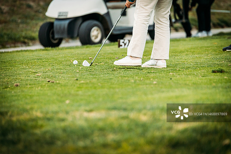 在绿地上开高尔夫球车的男人图片素材
