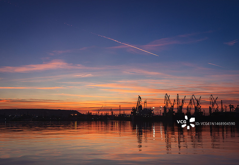 保加利亚瓦尔纳日落时湖边起重机剪影图片素材