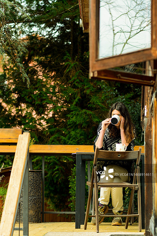 女人在秋季木屋里吃早餐图片素材