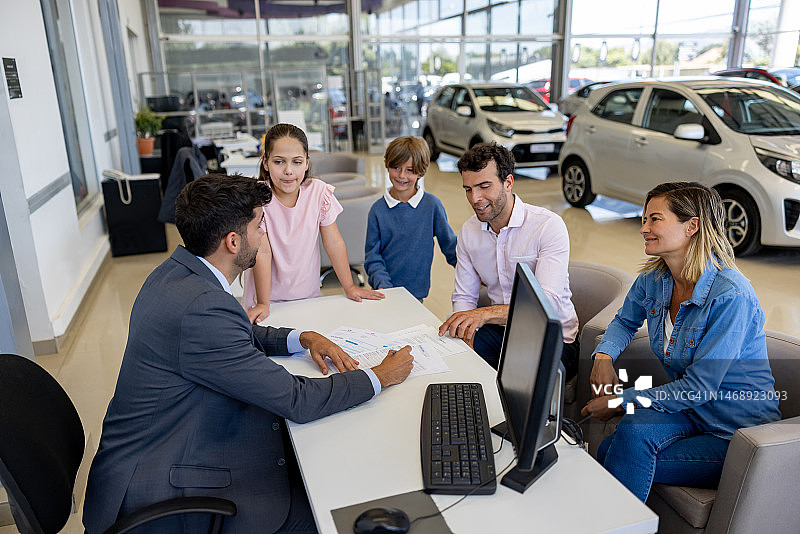一家人与销售员协商租赁协议条款图片素材