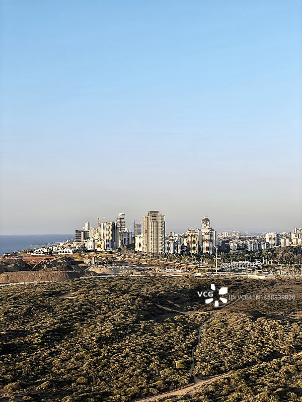 日落时分内坦亚市的城市景观，拥有现代建筑和绿色区域图片素材