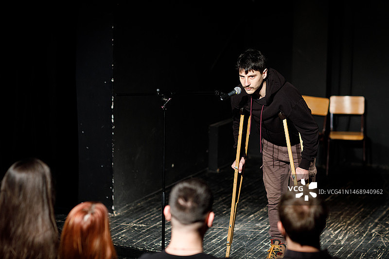 在剧院观众面前的年轻单口喜剧演员图片素材