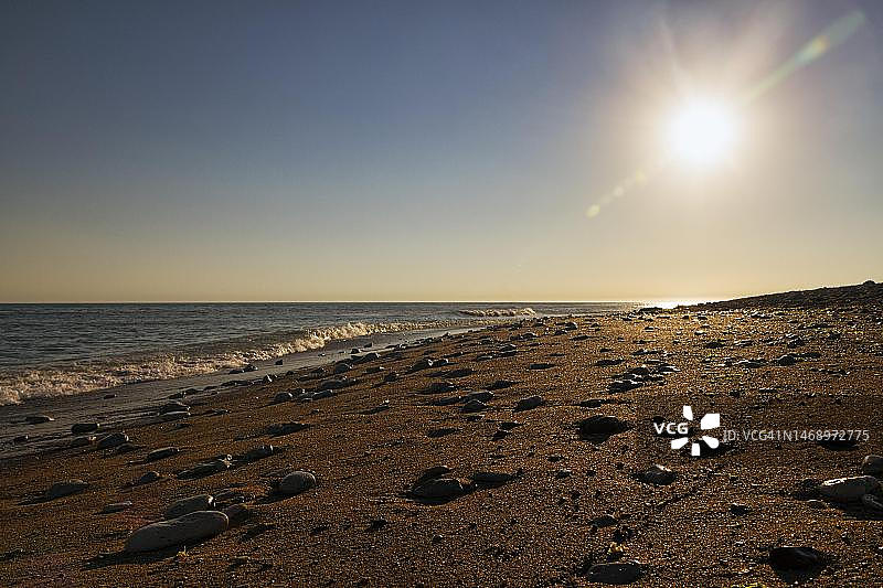 空旷沙滩上闪闪发光的鹅卵石图片素材