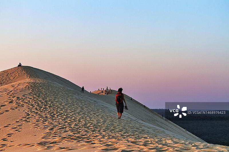 徒步者和游客在皮拉沙丘欣赏日落图片素材