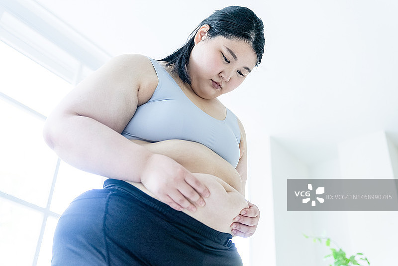 女子看着自己的肚子图片素材