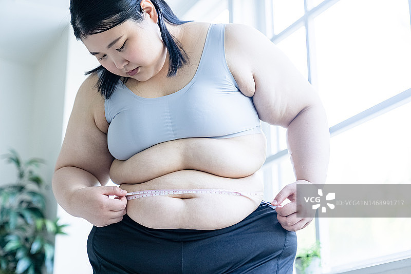 用卷尺测量腰围的女人图片素材