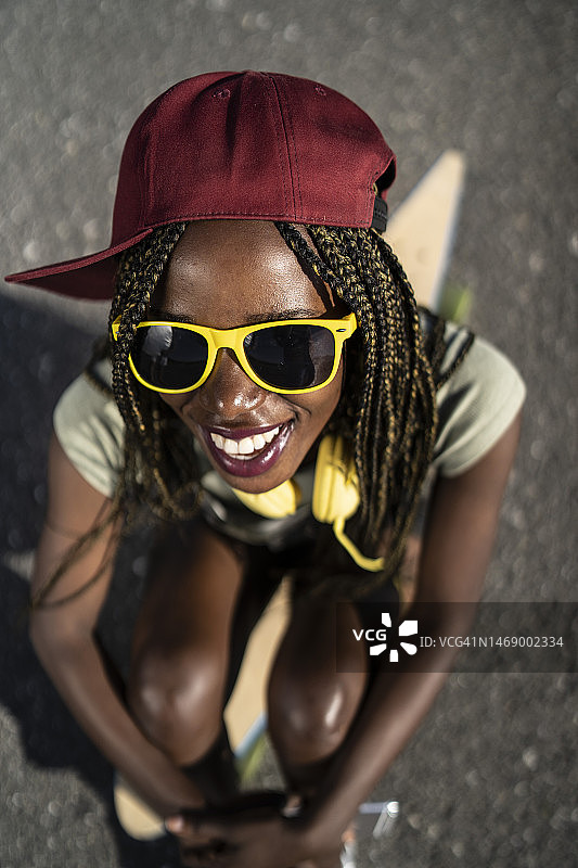 女子坐在滑板上图片素材