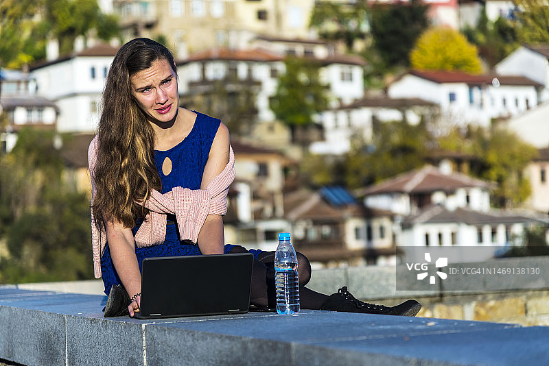 年轻女人在户外使用笔记本电脑图片素材