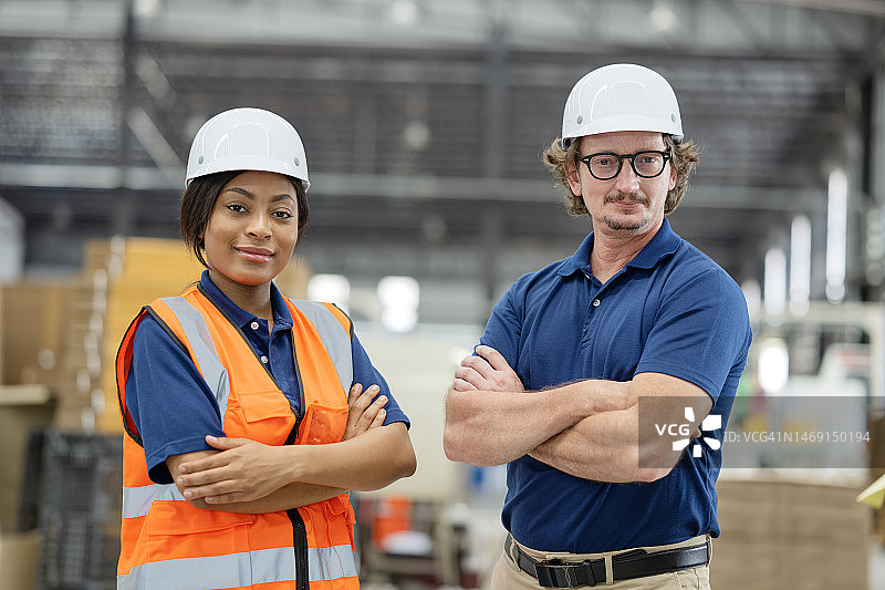 生产团队负责人确保瓦楞纸箱产品效率和质量的职责。生产计划经理和女工程师在纸板箱制造厂为包装业务工作。图片素材
