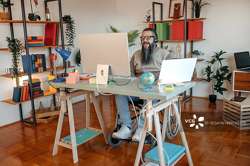 坐在轮椅上的男人在家工作，参加网络会议图片素材