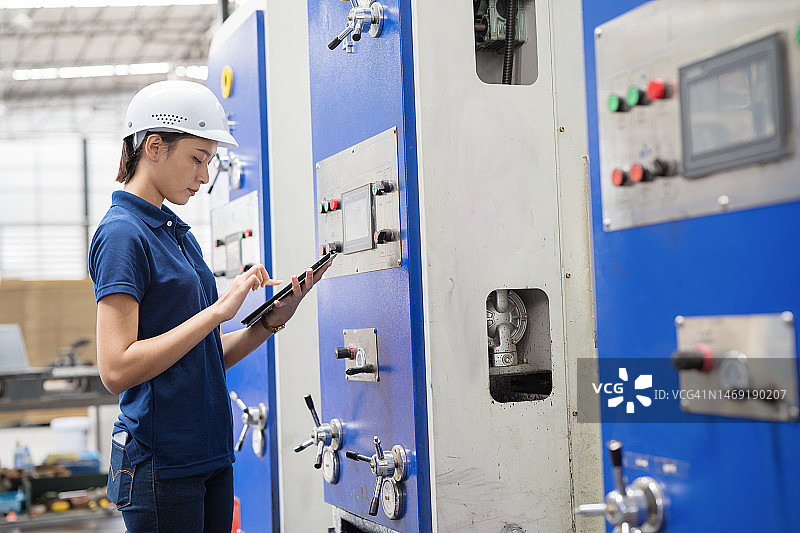 提高制造运营效率：女工程师使用平板电脑监控设备图片素材