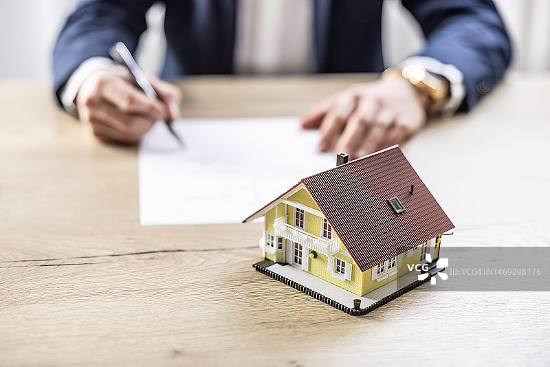 代理签署抵押贷款用于建造新的家庭住宅和公寓。新住房、房地产和抵押贷款的概念图片素材
