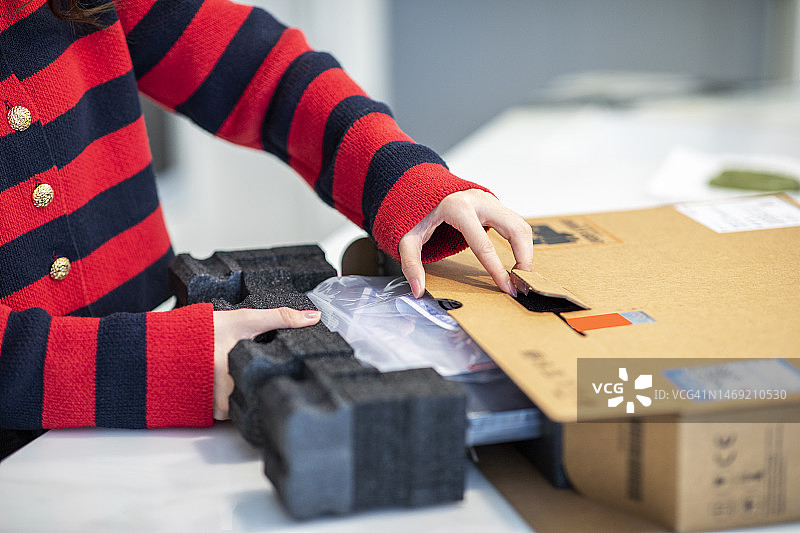 年轻亚裔女子打开作为礼物的新笔记本电脑图片素材