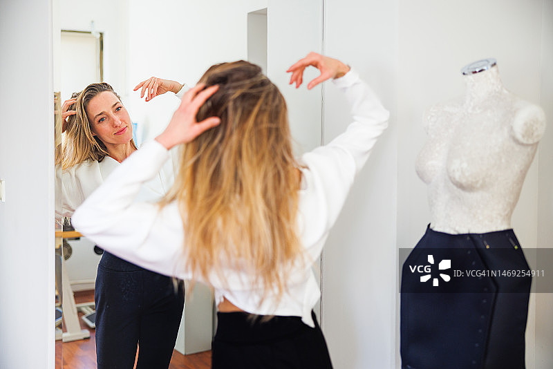 在服装沙龙试穿定制衬衫的美丽女人图片素材